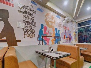 A restaurant interior with a wall mural, seating, and tables. - Townhouse RCC Park View Inn (Hyderabad)