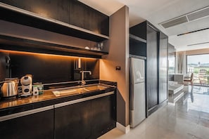 Eine moderne Küche mit einem Edelstahl-Kühlschrank, einer Kaffeemaschine und einem Wasserkocher auf der Arbeitsfläche.
