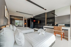 Ein modernes Hotelzimmer mit zwei Betten, einem Schreibtisch und Blick auf eine Brücke.