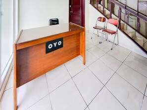 A reception desk with a sign reading 'OYO' in a hotel lobby with tiled flooring and a staircase in the background. - Luxury Deluxe DBL Retreat W/ Free Wifi and Parking (Curug)
