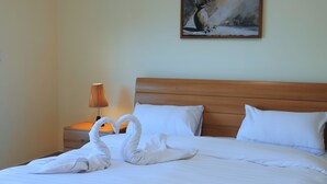Una habitación de hotel con una cama, una mesita de noche con lámpara y un cuadro en la pared.