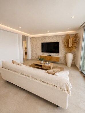 A modern living room with a sofa, a coffee table, a TV, and a decorative vase. - Villa Hamilton - Benitachell, Costa Blanca (Benitachell)