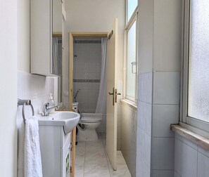 Ein Badezimmer mit Waschbecken, Spiegel, Toilette und Dusche.