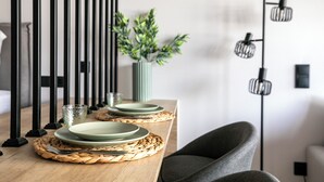 A dining table with plates, cutlery, and a woven placemat. - Nest Athens Retreat Studios (Tavros)