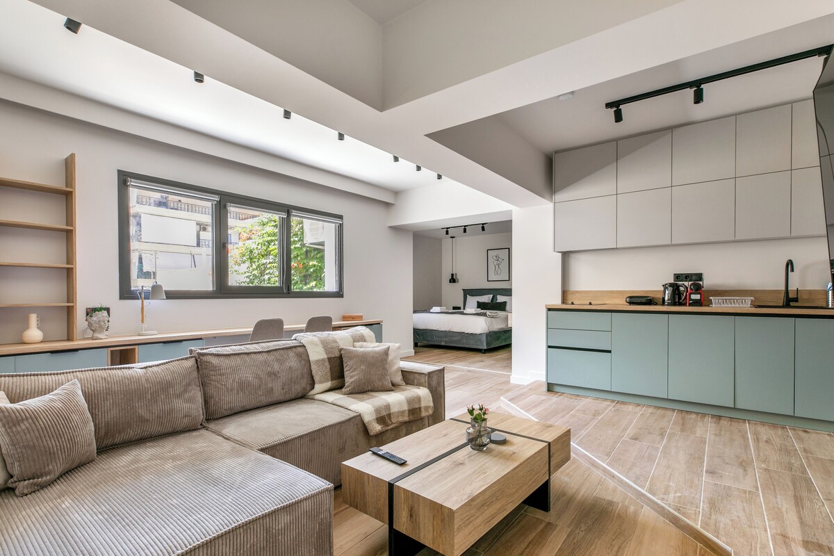 Ein modernes Wohnzimmer mit einer Couch, einem Couchtisch und Blick zur Küche.