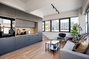 Eine moderne Küche mit grauen Schränken, einer Holz Arbeitsplatte und einem eingebauten Backofen.