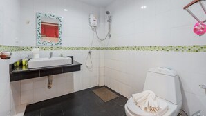 A bathroom with a white sink, a toilet, a shower, and a mirror with a green leaf frame. - Relaxing 1BR Close to Beach & Lake- relife C200 (Tambon Rawai)