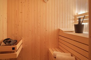 A wooden sauna with benches, a bucket, and a towel rack. - Ten-bedroom Group Villa Near the Shores (Nieuwvliet)