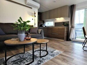 Ein modernes Wohnzimmer mit einer Couch, einem Couchtisch und einer Zimmerpflanze.