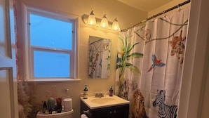A bathroom with a toilet, sink, and shower curtain with animal prints. - 1 Bed, 1 Bath - Fully Furnished Modern Del Rey Home (Los Angeles)