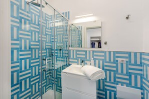 A modern bathroom with a glass shower enclosure, a white sink, and a mirror above the mirror cabinet. - Bellamore (Piano di Sorrento)