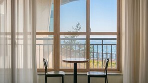A room with a large window, two chairs, and a small table. - Pohang Baritdol Pension (Pohang)