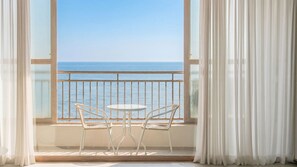 Un balcón con dos sillas y una mesa, con vistas al mar.