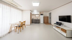 A modern apartment with a dining area, kitchenette, and a flat-screen TV. - Pohang Baritdol Pension (Pohang)