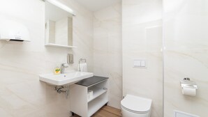 A modern bathroom with a white sink, mirror, and toilet. - Altiora Prestige Residence 202 (Gradac)