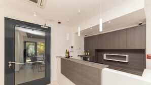 A modern kitchen with a dark wood countertop, a glass door, and a view of the outdoors. - Altiora Prestige Residence 202 (Gradac)