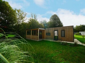 Ein modernes Holzgebäude mit einer überdachten Veranda und einer Tür.