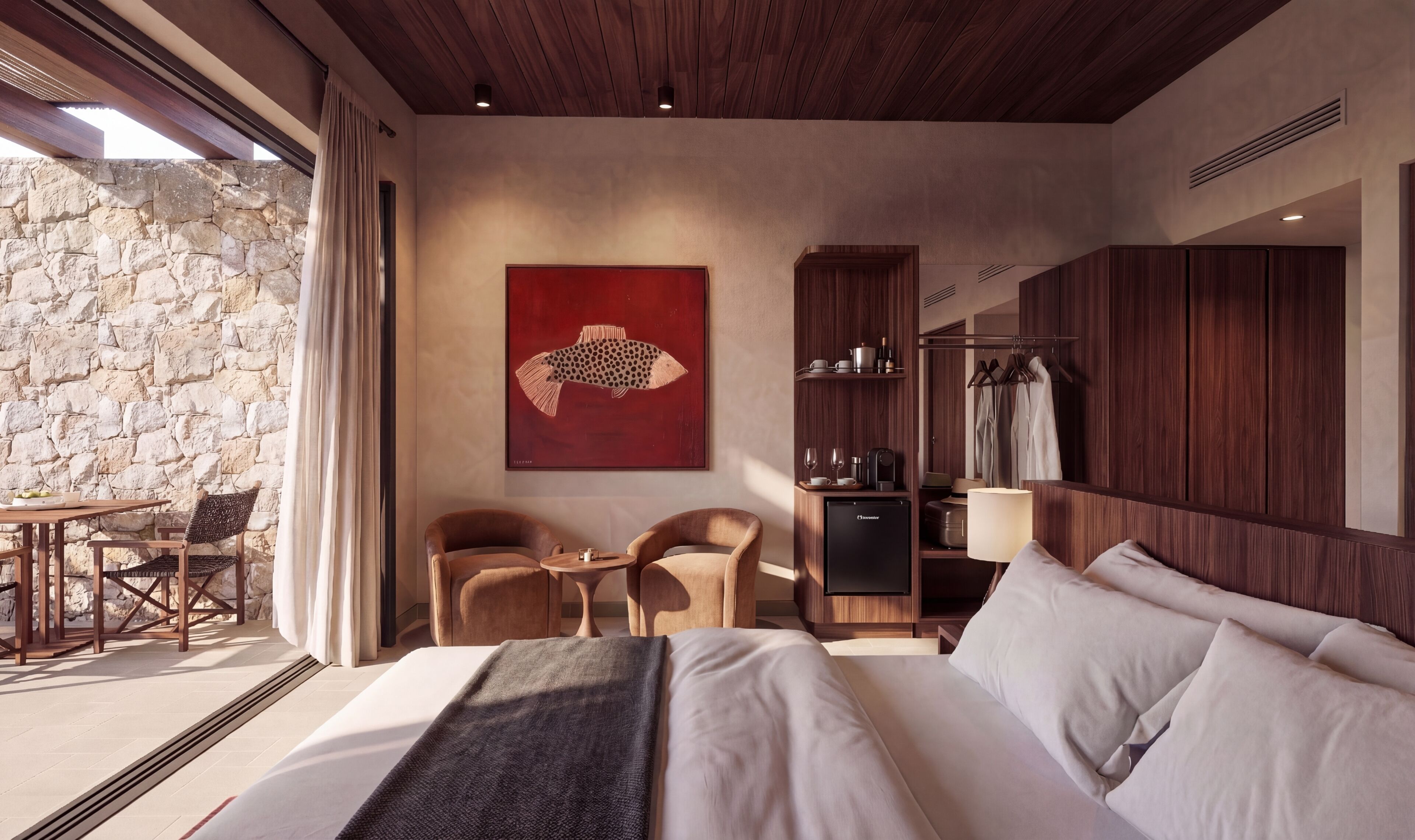 Una habitación de hotel moderna con una pared de piedra, una cama grande, dos sillones, un escritorio y un armario.