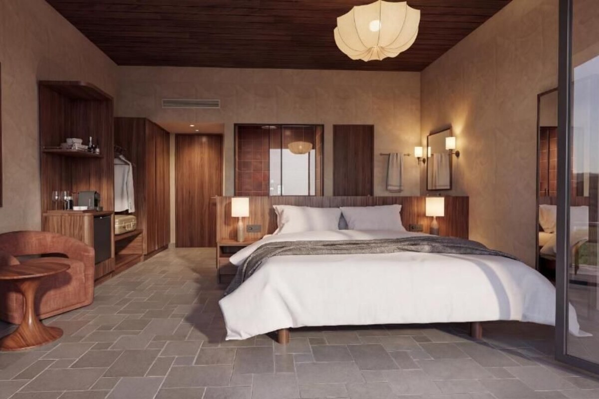 A modern bedroom with a large bed, wooden furniture, and a glass wall.