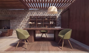 Uma sala de jantar moderna com parede de pedra, teto de madeira e uma estante embutida.
