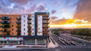 A multi-story building with balconies, a parking lot, and a road with vehicles. - Charming apartment in pleasant Denver with cool AC and fitness room (Denver)
