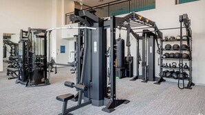 A gym with various exercise equipment, including weight machines and free weights. - Charming apartment in pleasant Denver with cool AC and fitness room (Denver)