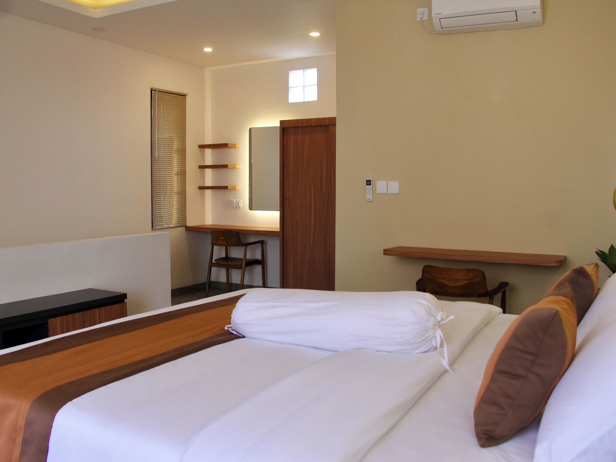 Una habitación de hotel con cama, escritorio, silla y una mesita.