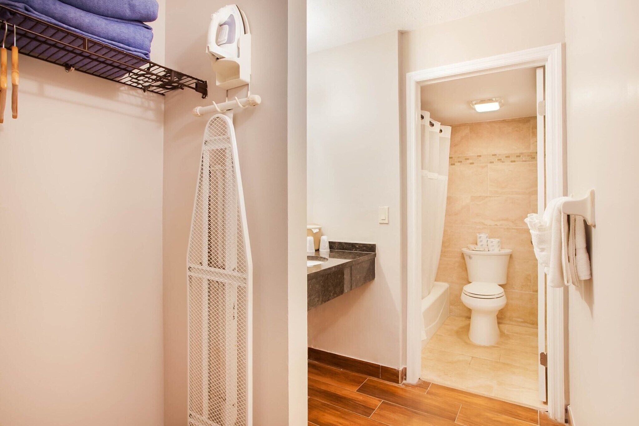 A bathroom with a toilet, sink, and shower area.