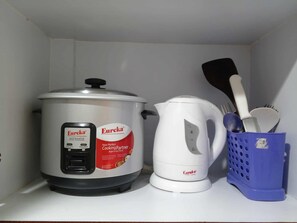 A kitchen with a rice cooker, a kettle, and a utensil holder. - Grand Riviera Suites – Manila Bay Stay (Manila)
