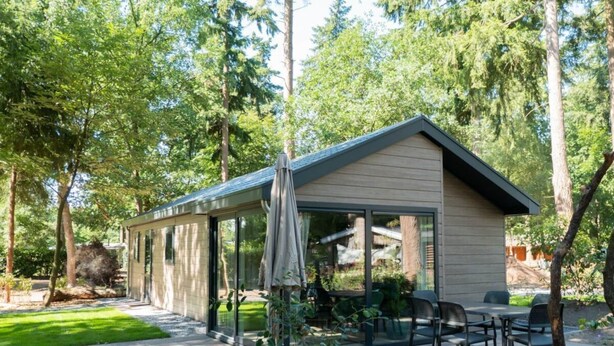 A modern house with a patio, outdoor seating, and a view of the surrounding forest. - Holiday Home in Maarn With Terrace (Maarn)