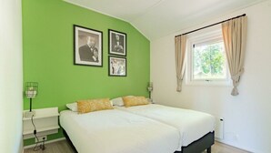 A room with two beds, a window with curtains, and three framed pictures on the wall. - Holiday Home in Maarn With Terrace (Maarn)
