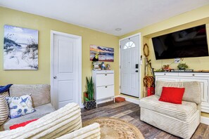A living room with a sofa, a television, a painting, and a door. - Private Deck, Workspace! Bradenton Stay Near Dtwn (Bradenton)