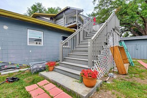 A residential building with a grey exterior, a wooden staircase, and a white fence. - Private Deck, Workspace! Bradenton Stay Near Dtwn (Bradenton)