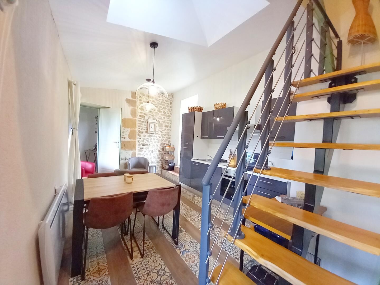 A modern interior with a dining area, kitchen, and staircase.