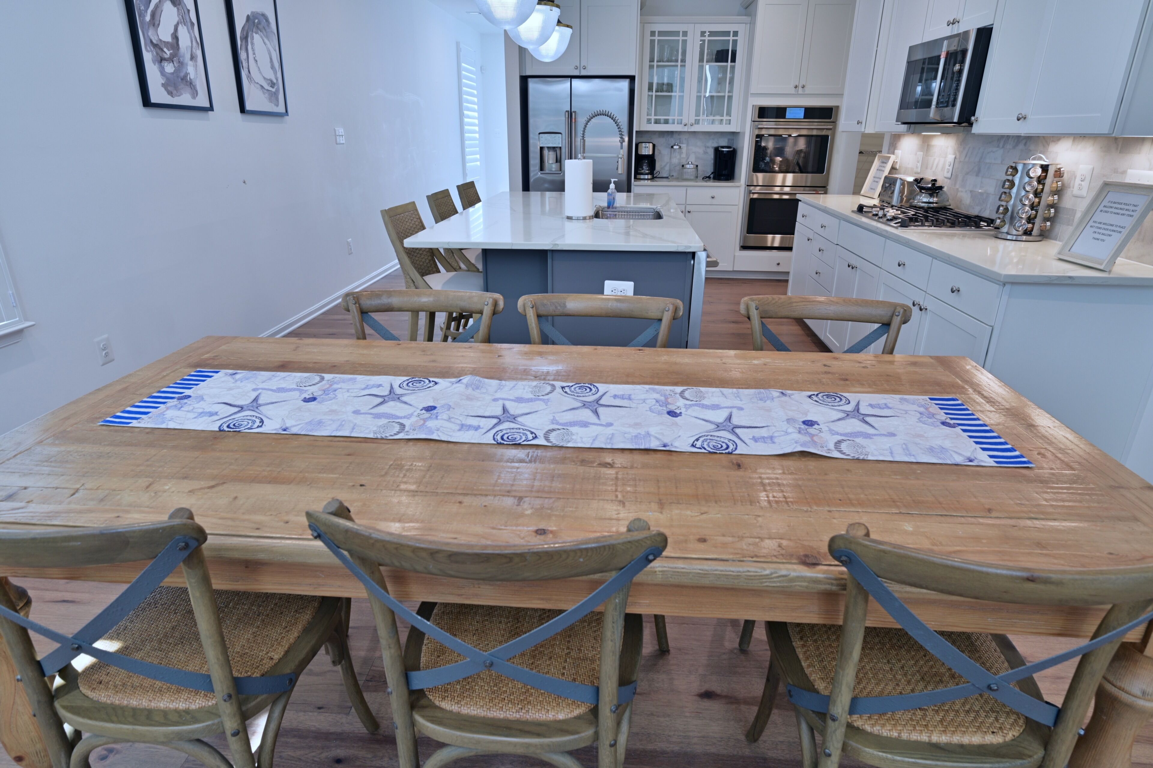Un coin repas avec une table en bois, quatre chaises et une cuisine en arrière-plan.