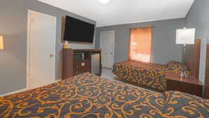 A hotel room with two beds, a TV, a desk, and a mirror. - 2 Queen Beds|Smk|Kitchenette (Houston)