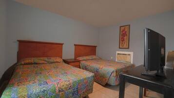 Una habitación de hotel con dos camas, un televisor y una mesita.