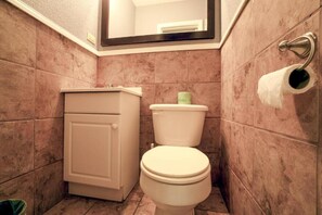 A bathroom with a toilet, a cabinet, and a towel rack.