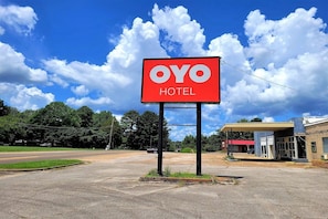 Un cartell d'hotel amb la inscripció 'OYO HOTEL', una benzinera i una carretera al fons.