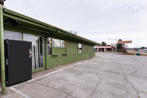 Un edifici amb façana verda, un rètol que indica un restaurant i un frigorífic gran i negre.