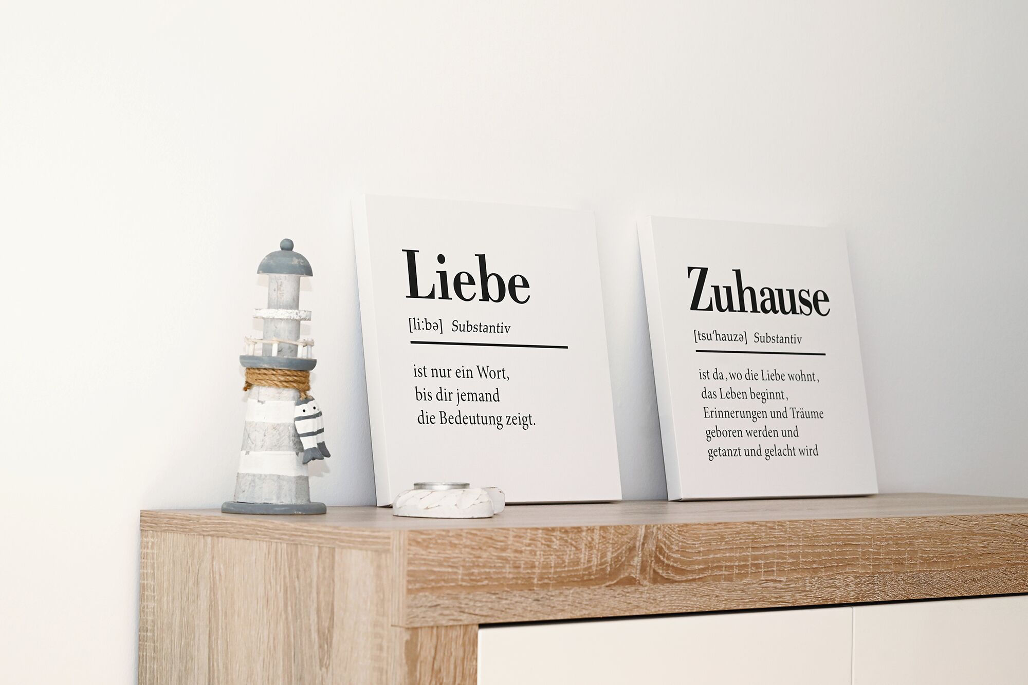 Two framed signs with German text on a wooden shelf.