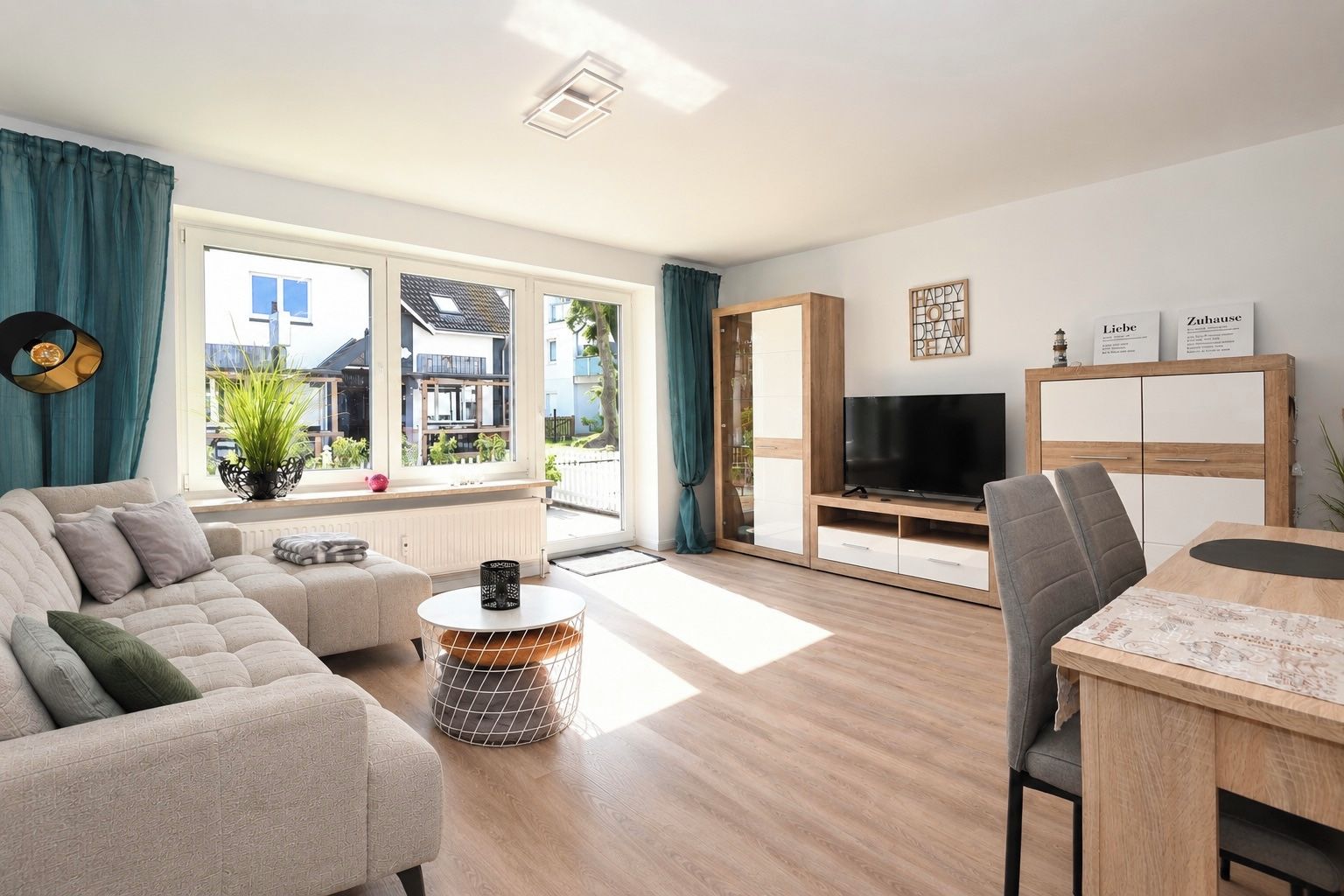 Un salon moderne avec un canapé, un meuble pour la télévision et un coin repas.