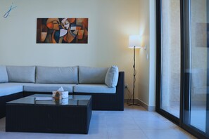 A modern living room with a sofa, a coffee table, a lamp, and a painting on the wall.
