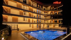 Un hotel de varios pisos con zona de piscina, balcones y un cartel que dice 'HOTEL FAI'.