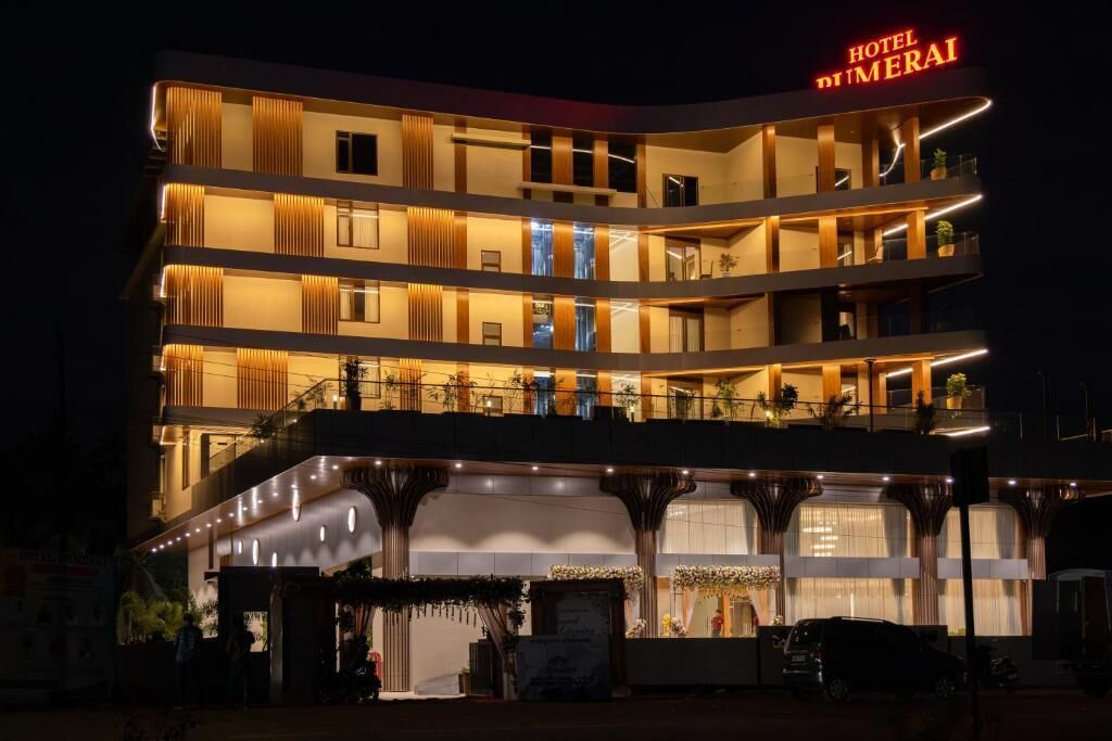 A multi-story hotel with balconies, a prominent sign, and a well-lit entrance.