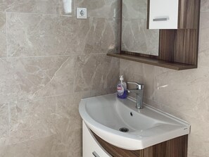 A bathroom with a white sink, a mirror above it, and a bottle of hand soap on the counter. - Studio Apartment Vir 2 (Vir)