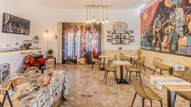A restaurant with a bar area, tables, chairs, and a mural on the wall. - THAT'S LOVE JAZZ FIUMICINO (Fiumicino)