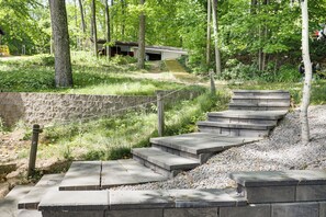 A set of concrete outdoor stairs leading up a hill, surrounded by trees and greenery. - Boat, Fish, Relax! Crescent Lake Retreat w/ Dock (Rhinelander)