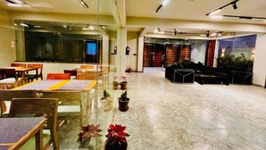 A spacious lobby with a seating area, a reception desk, and a large window.