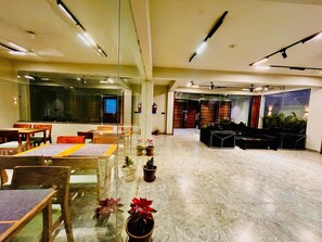A spacious lobby with a seating area, a reception desk, and a large window.